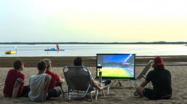 Världens smartaste mobila multimediaprojektor projicerar på stranden.